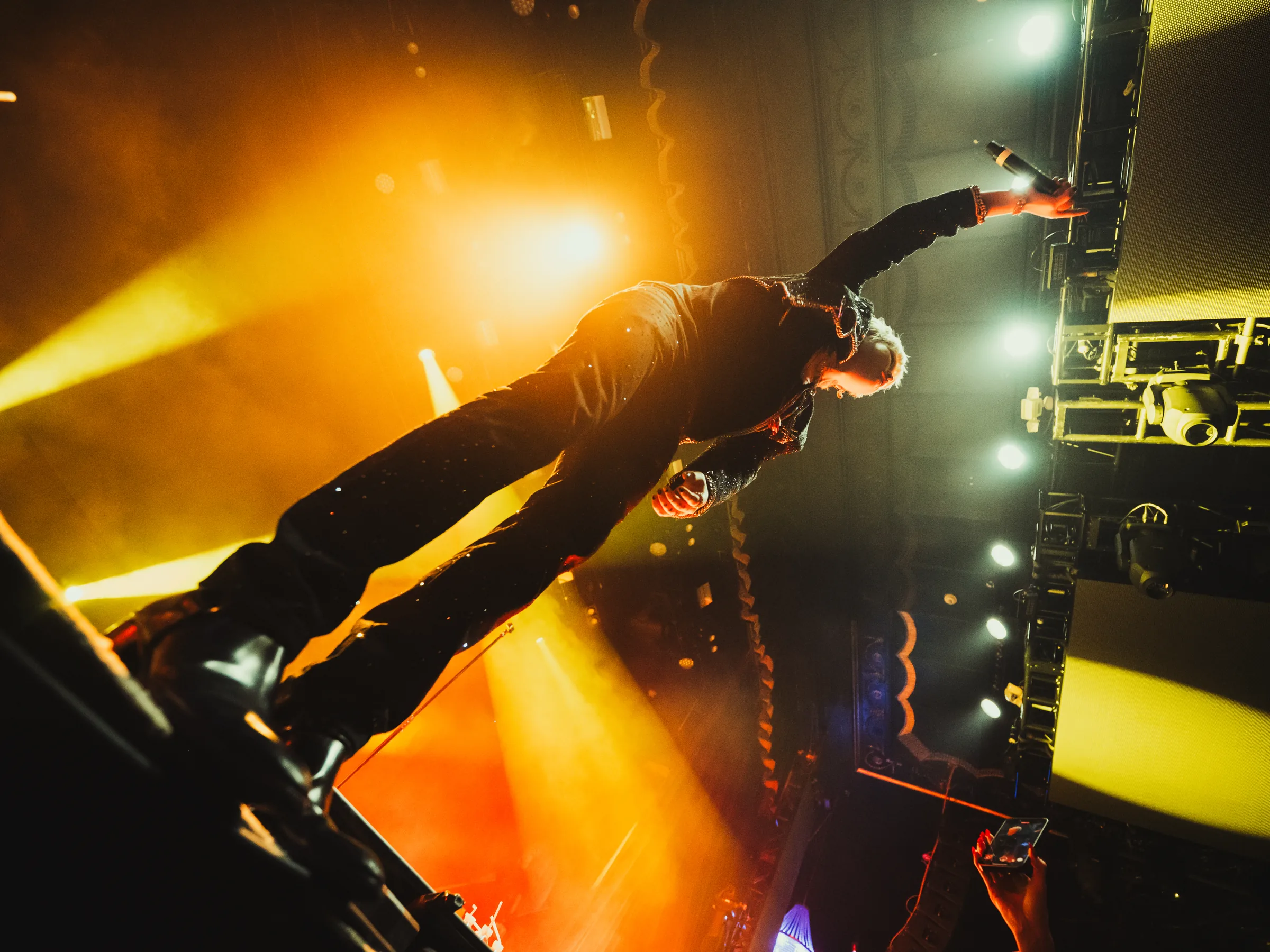 ASH ISLAND performing from a low angle under orange light in Boston