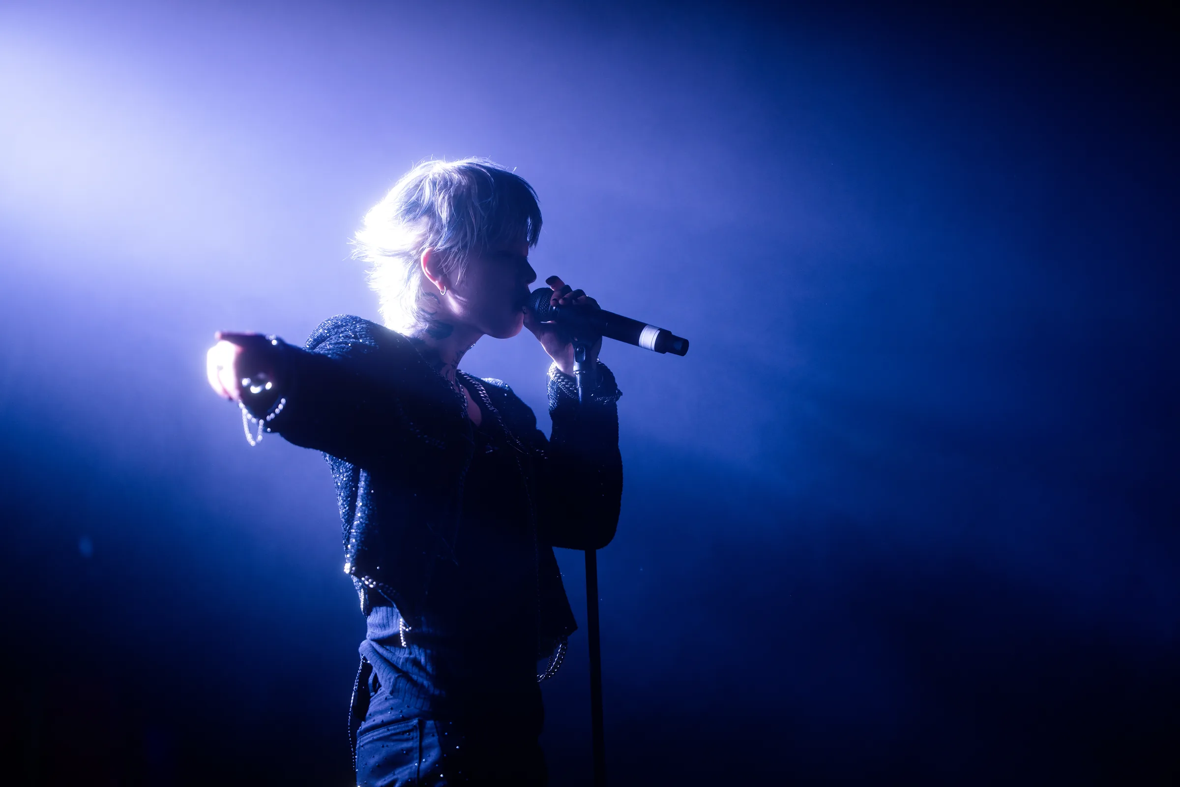 ASH ISLAND singing in profile under blue backlight