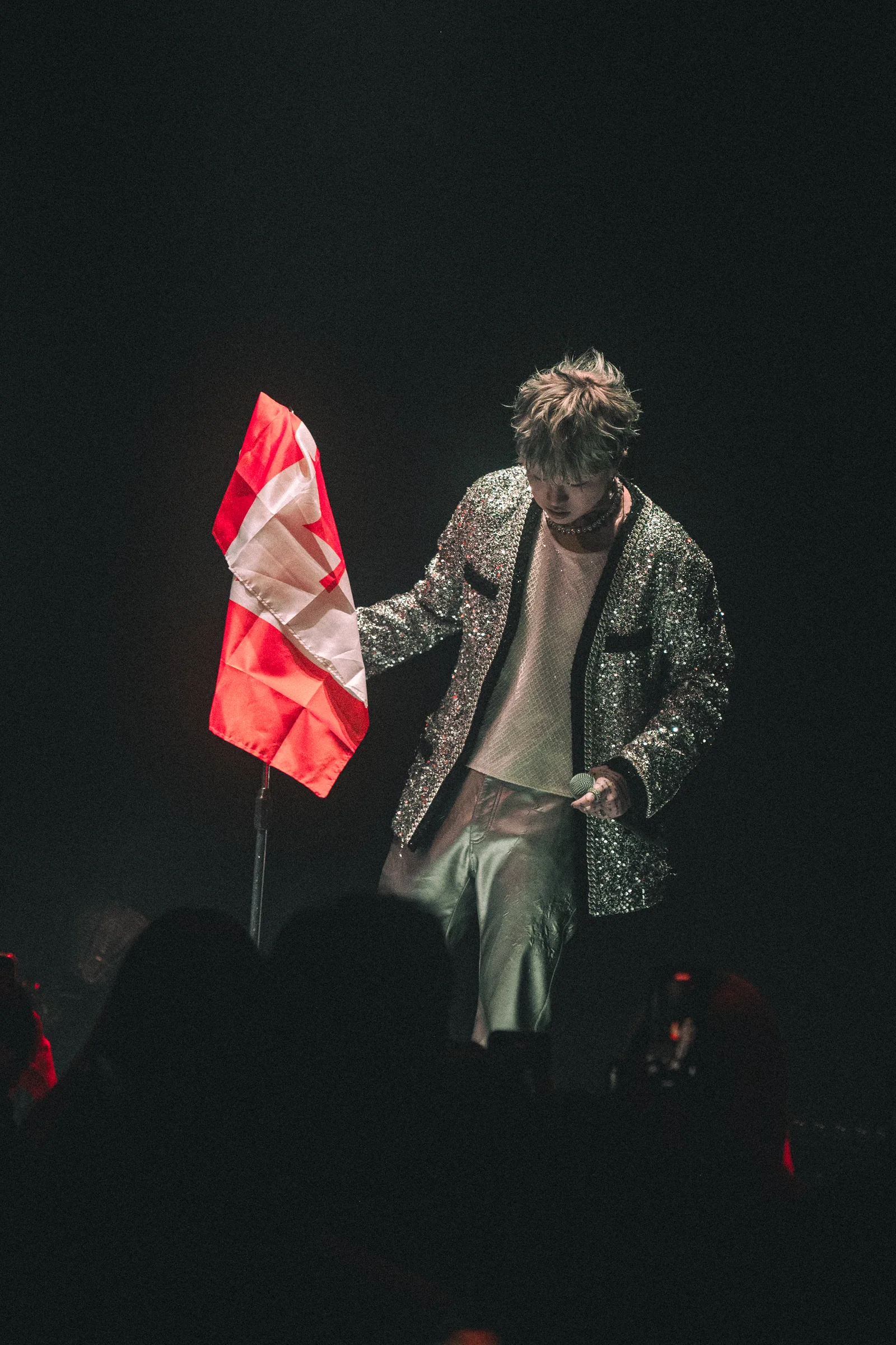 ASH ISLAND holding a red and white flag on stage in Vancouver